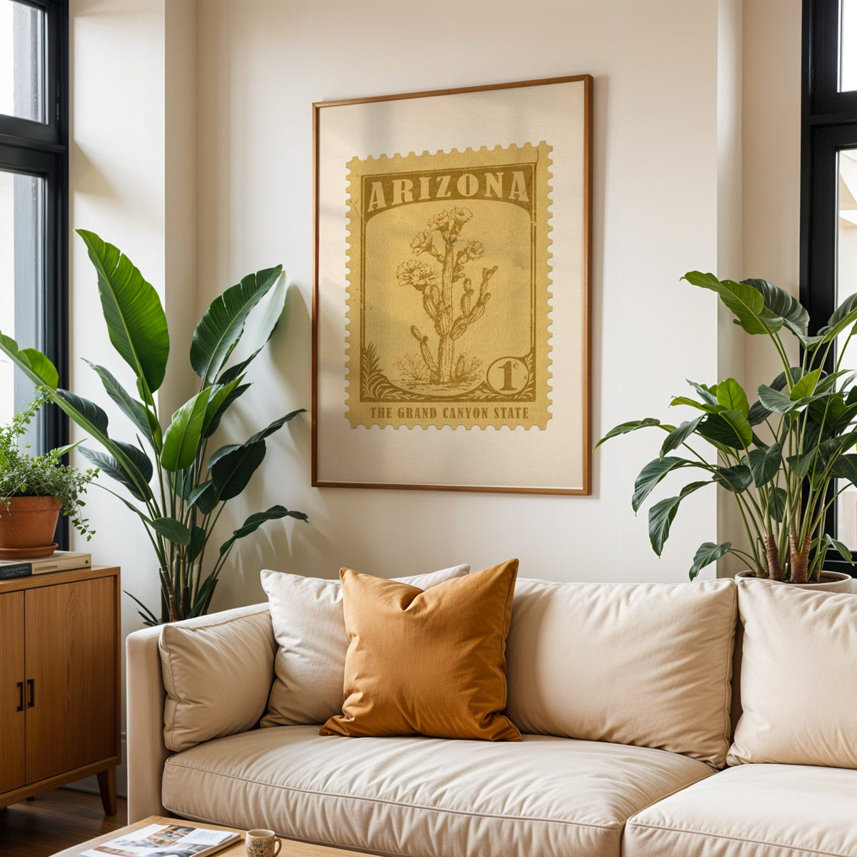 Arizona state flower print framed above a cream sofa with an ochre cushion and large plants either side