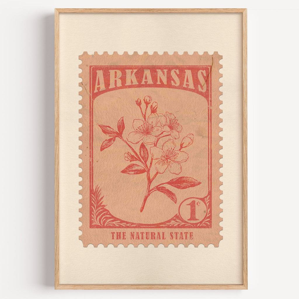 Arkansas state flower stamp print in terracotta on blush, light oak frame on a plain white wall