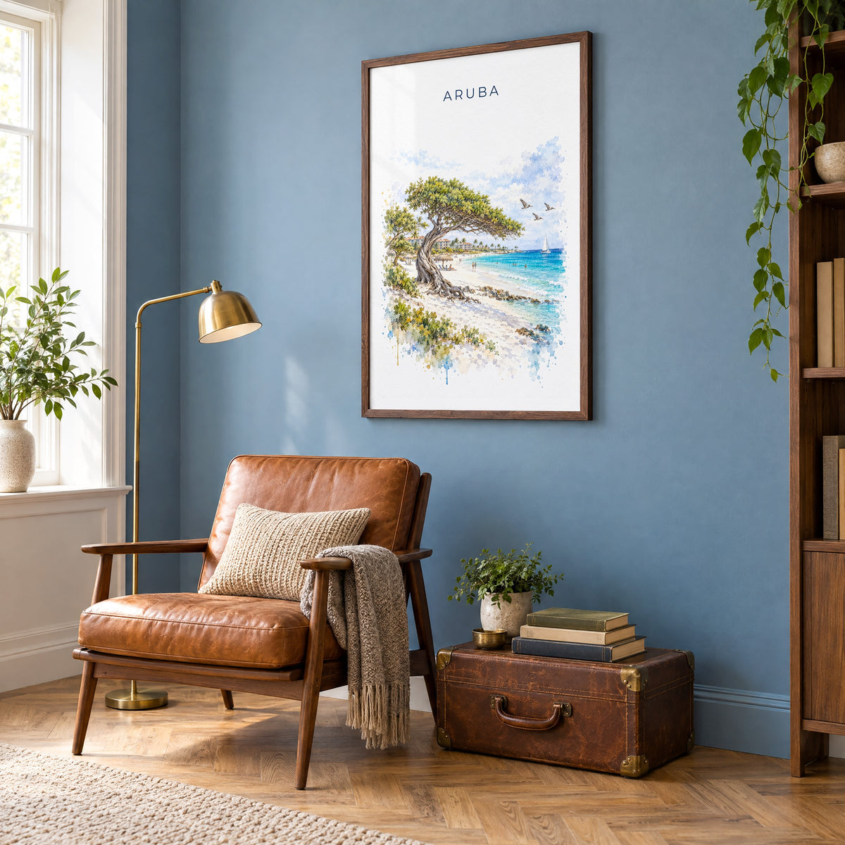 Aruba watercolor print in a walnut frame on a blue wall above a leather armchair in a reading nook