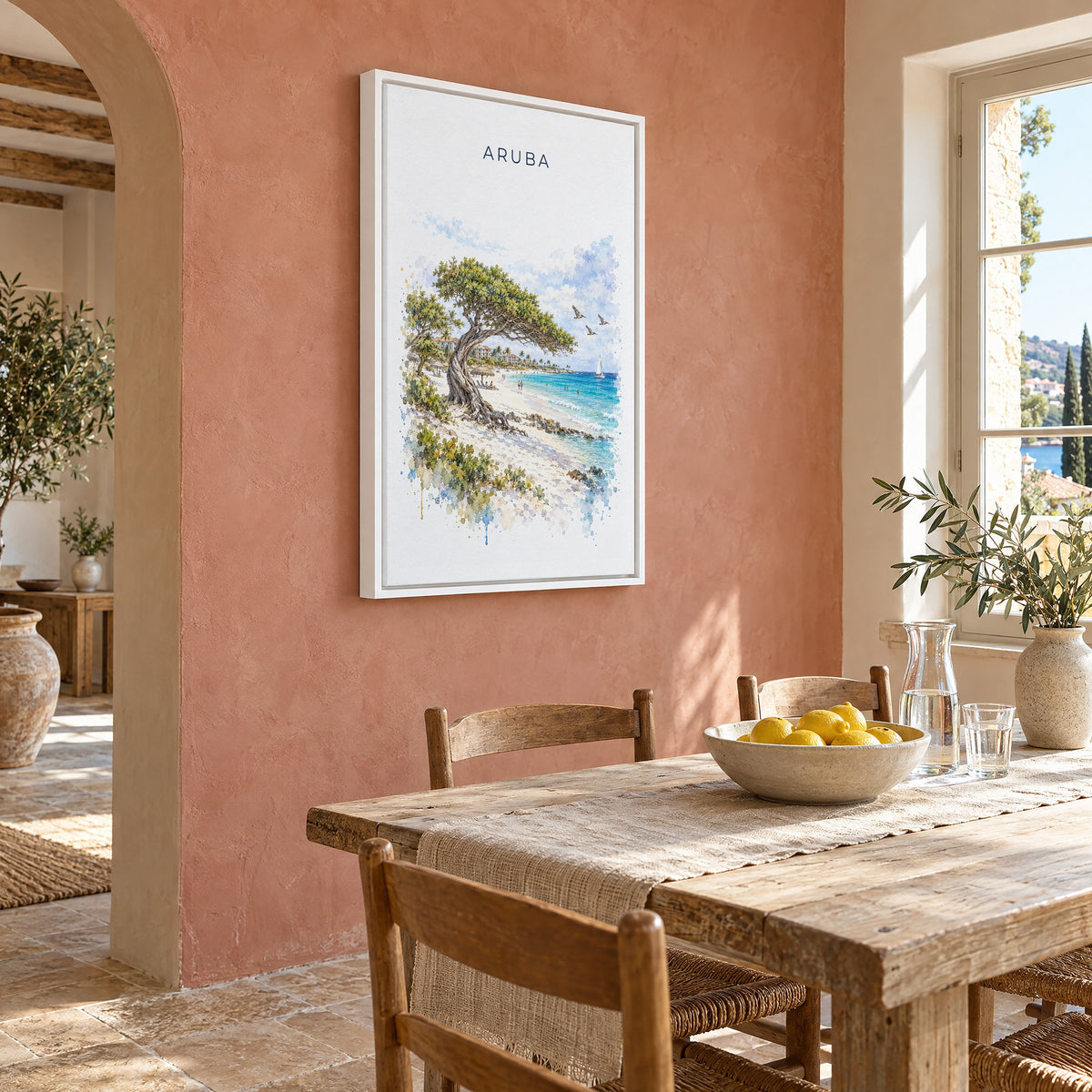 Aruba watercolor print as a white floater canvas on a terracotta wall above a rustic dining table