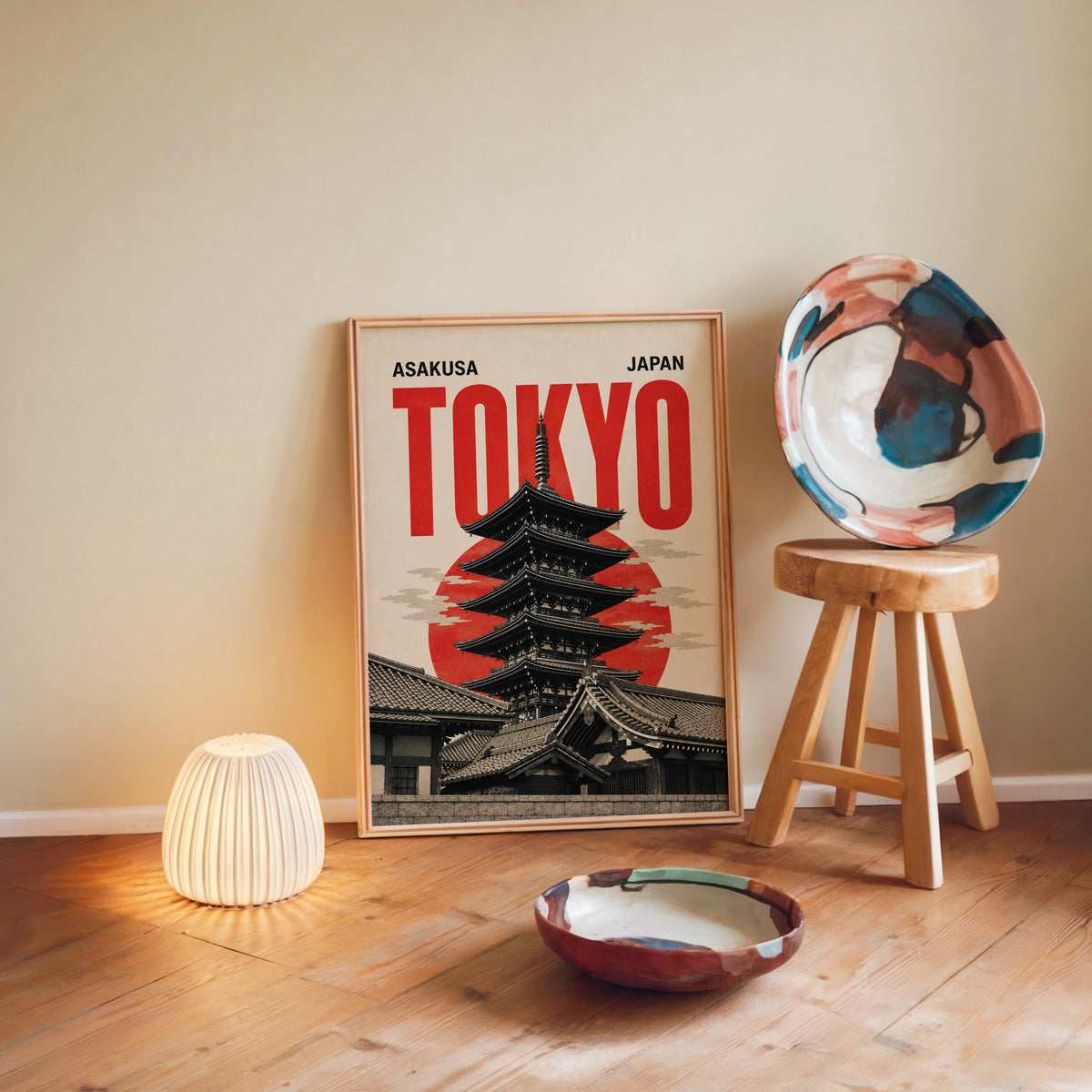 Asakusa Tokyo pagoda poster in a light wood frame leaning on a wooden floor by a glowing lamp and stool