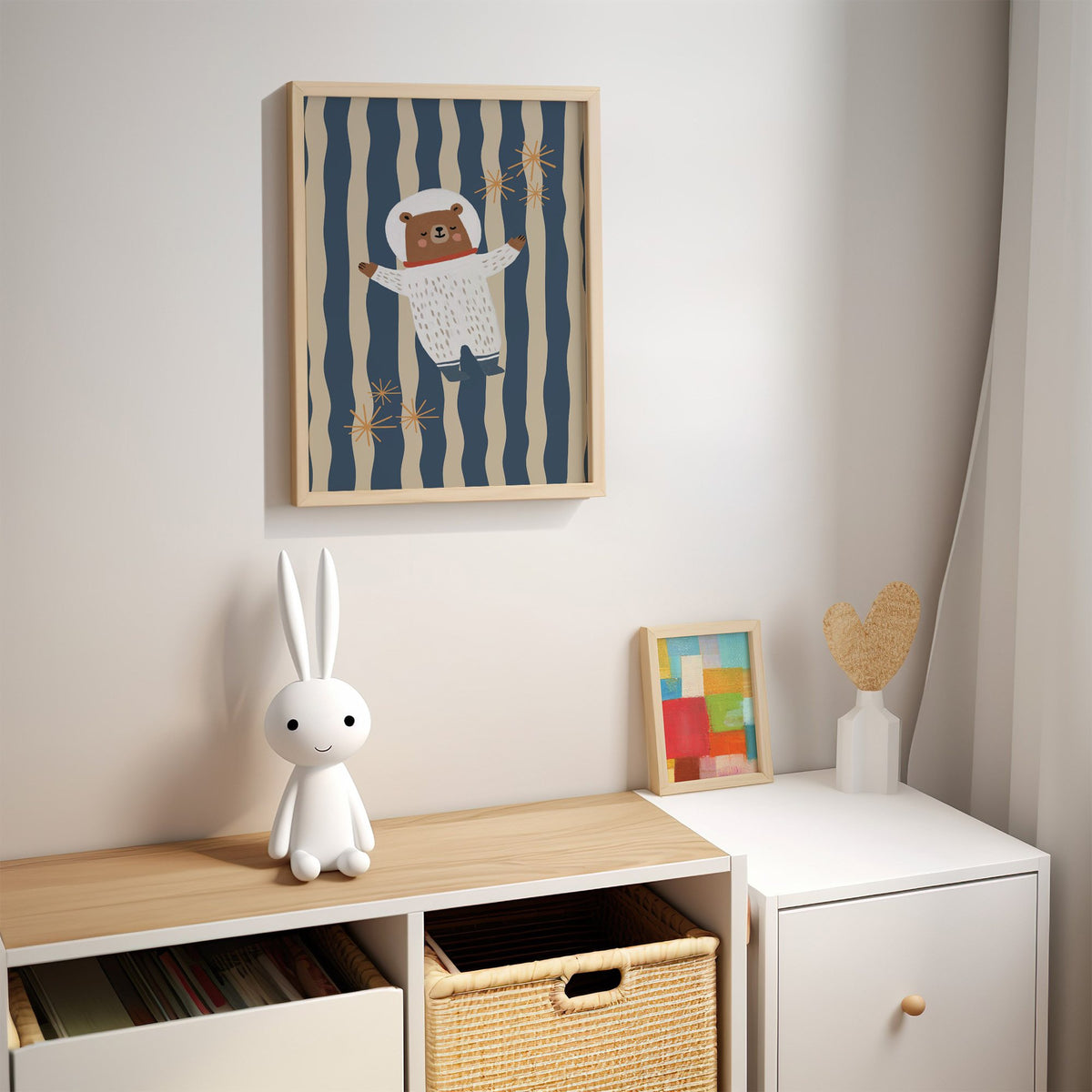 Astronaut bear wavy stripe nursery print in an oak frame above a kids cubby shelf with a woven basket and bunny lamp