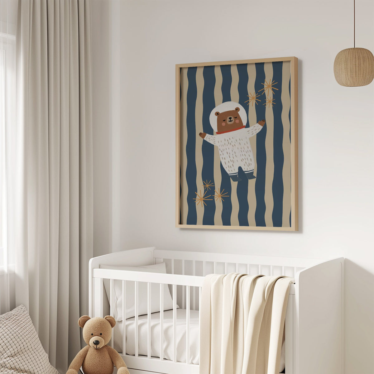 Astronaut bear wavy stripe nursery print in an oak frame above a white crib with a teddy bear