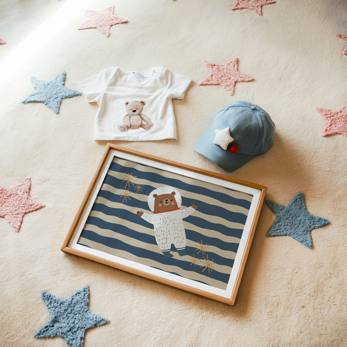 Landscape astronaut bear wavy stripe nursery print in a matted oak frame on a star rug with a baby tee