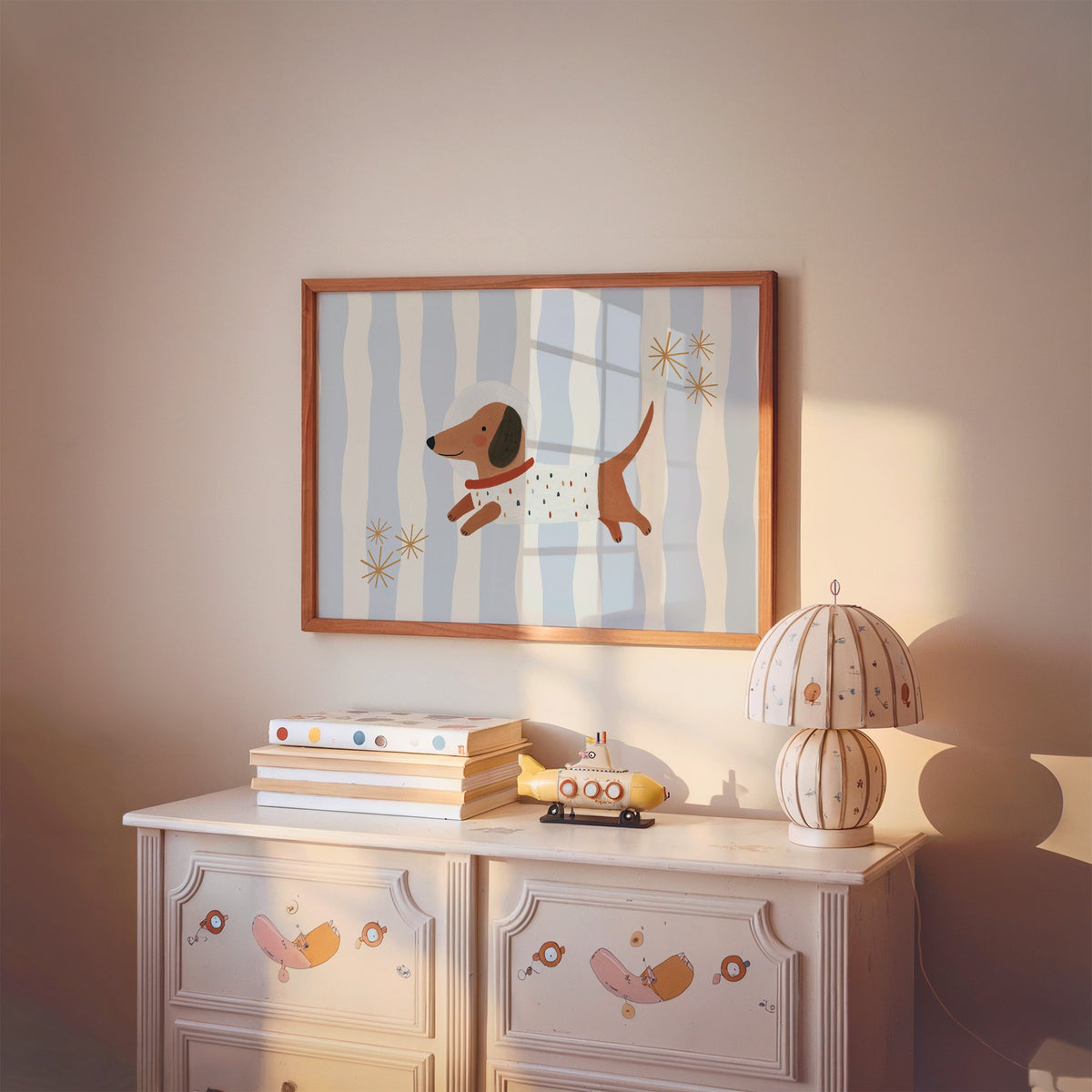 Landscape astronaut dachshund wavy stripe nursery print in a cherry wood frame above a painted dresser and lamp
