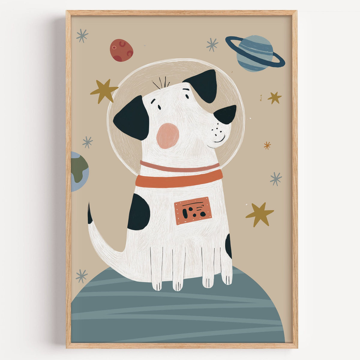 Spotted dog astronaut planet nursery print in a light oak frame on a plain white wall
