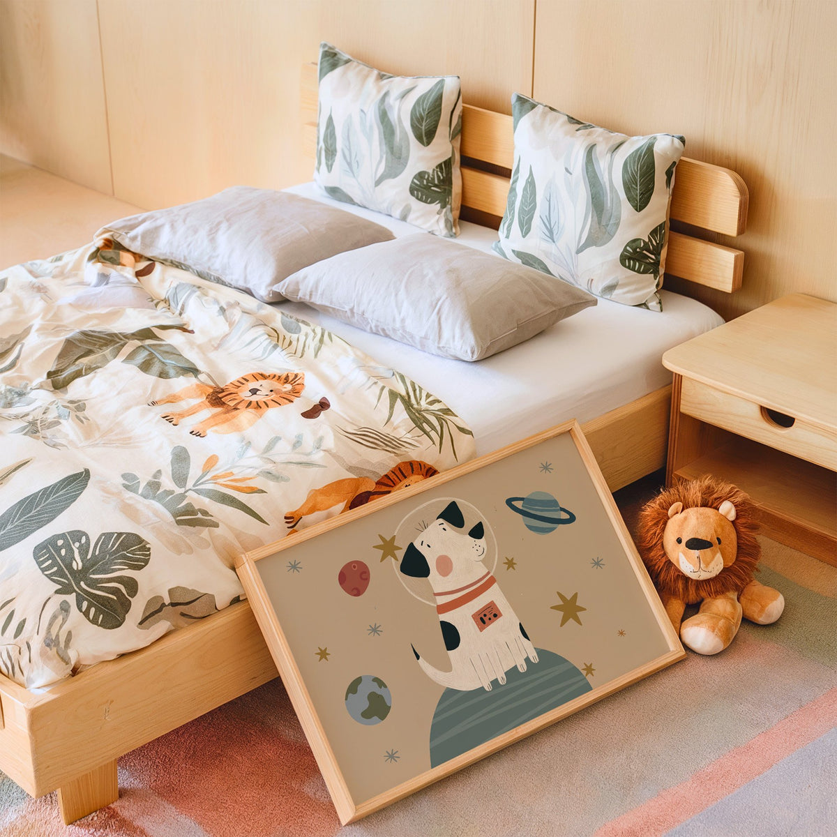 Landscape spotted dog astronaut planet nursery print in an oak frame leaning on a kids bed by a lion plush