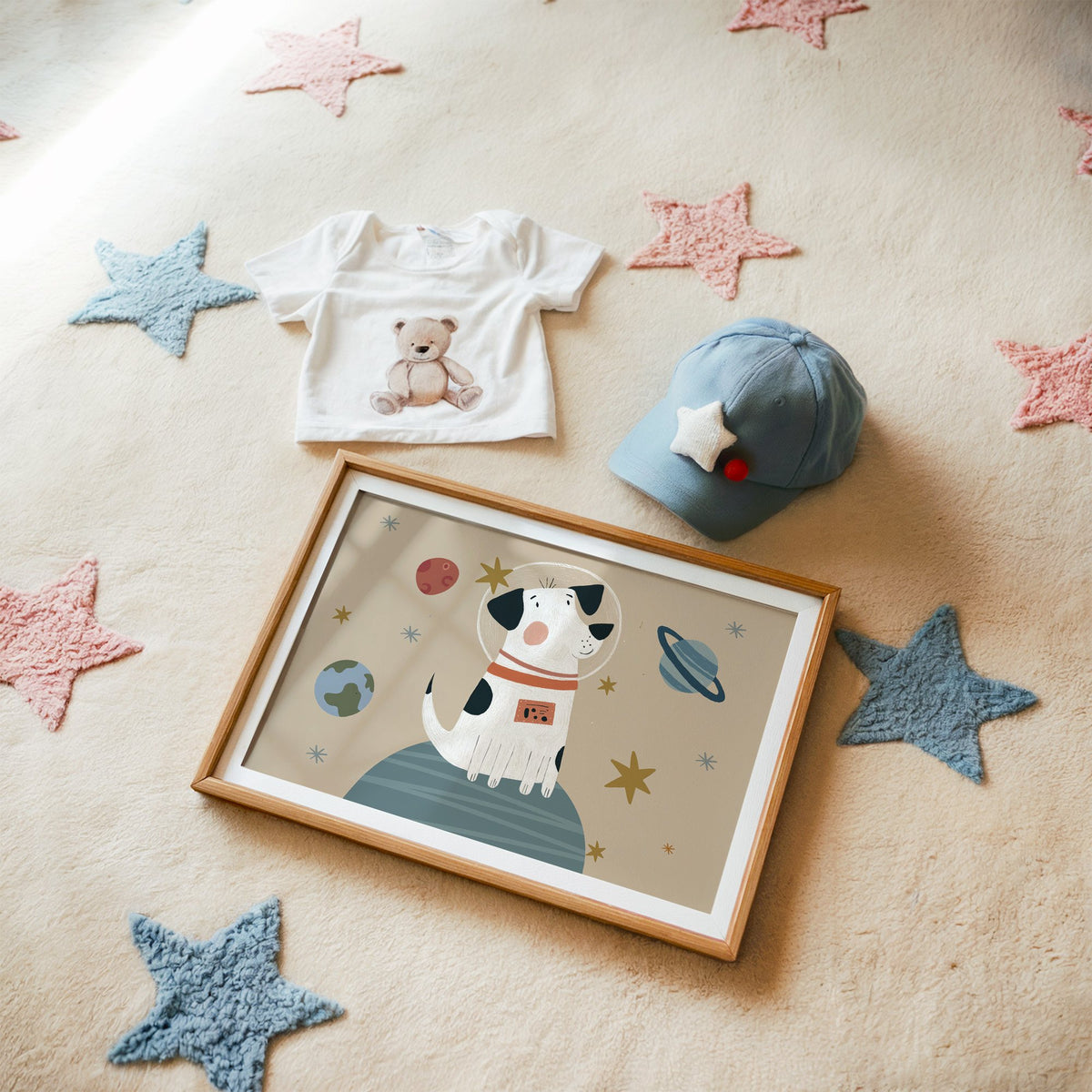 Landscape spotted dog astronaut planet nursery print in a matted oak frame on a star rug with a baby tee