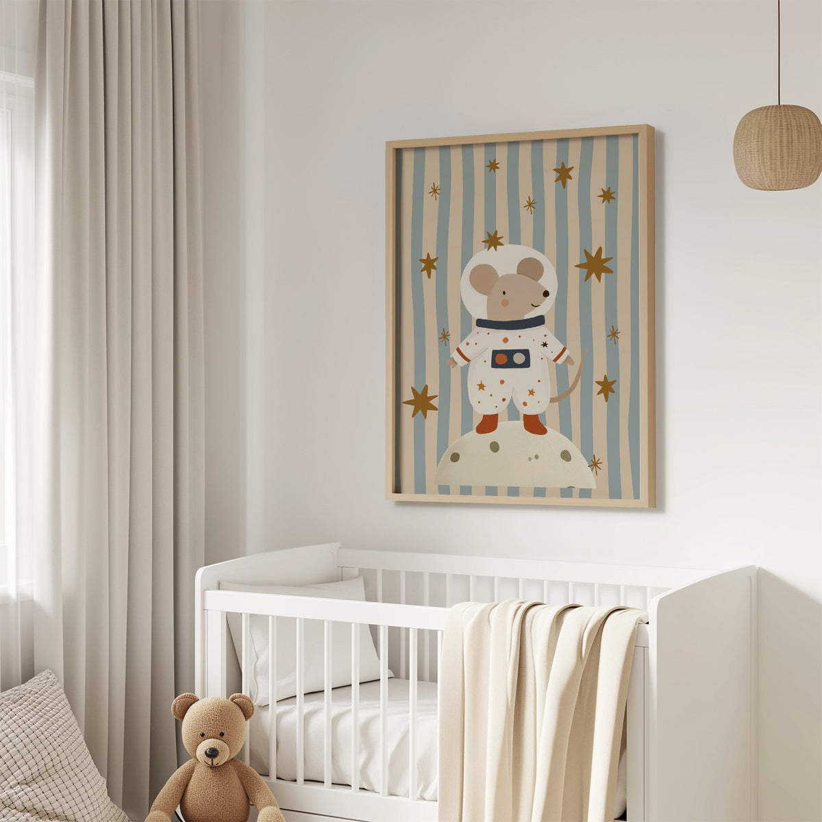 Astronaut mouse on the moon nursery print in an oak frame above a white crib with a teddy bear