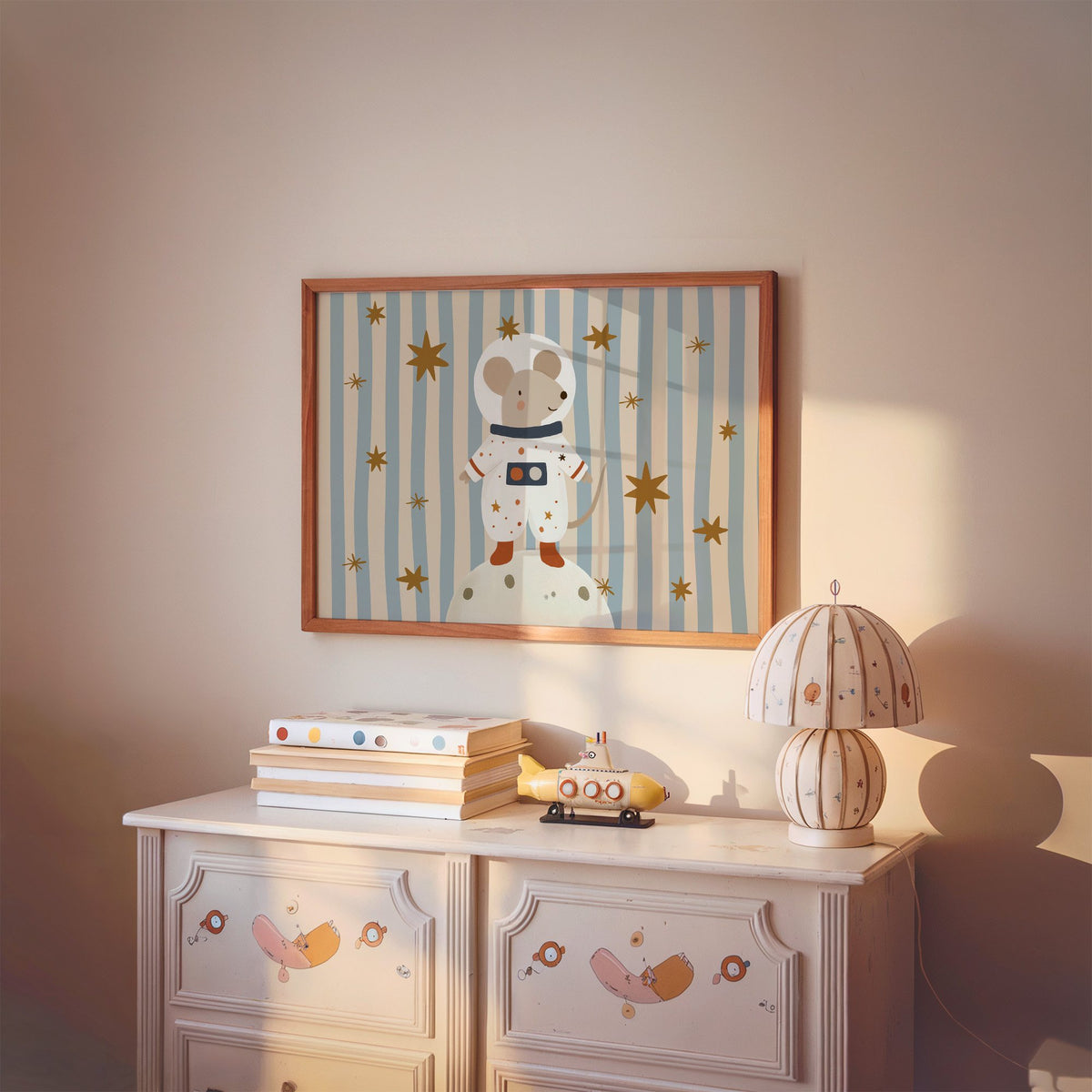 Landscape astronaut mouse on the moon nursery print in a cherry wood frame above a painted dresser and lamp