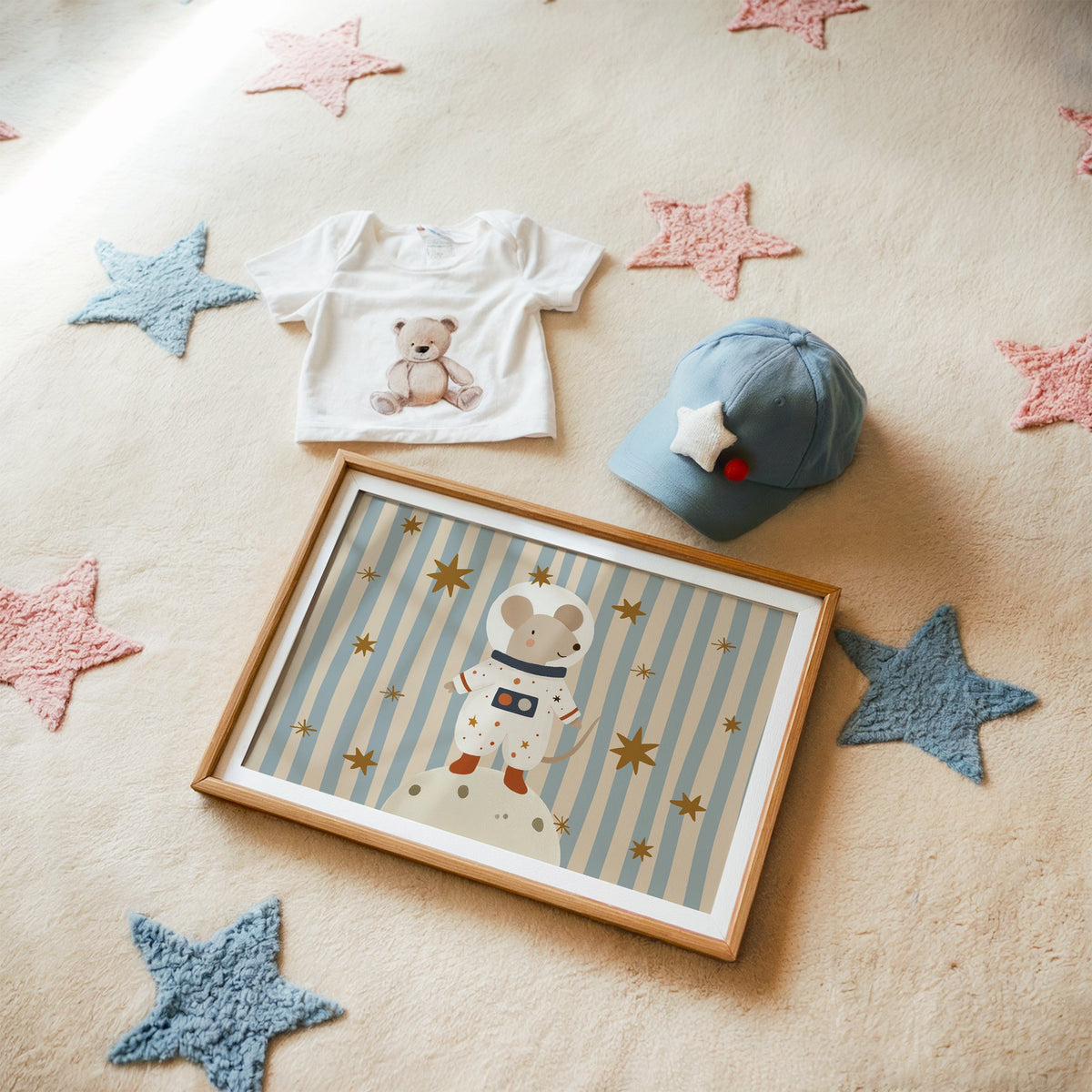 Landscape astronaut mouse on the moon nursery print in a matted oak frame on a star rug with a baby tee