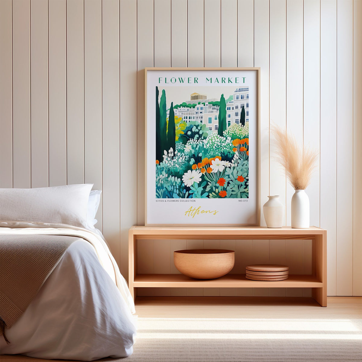 Athens flower market print in an oak frame on a wood bench against a white shiplap bedroom wall with pampas grass
