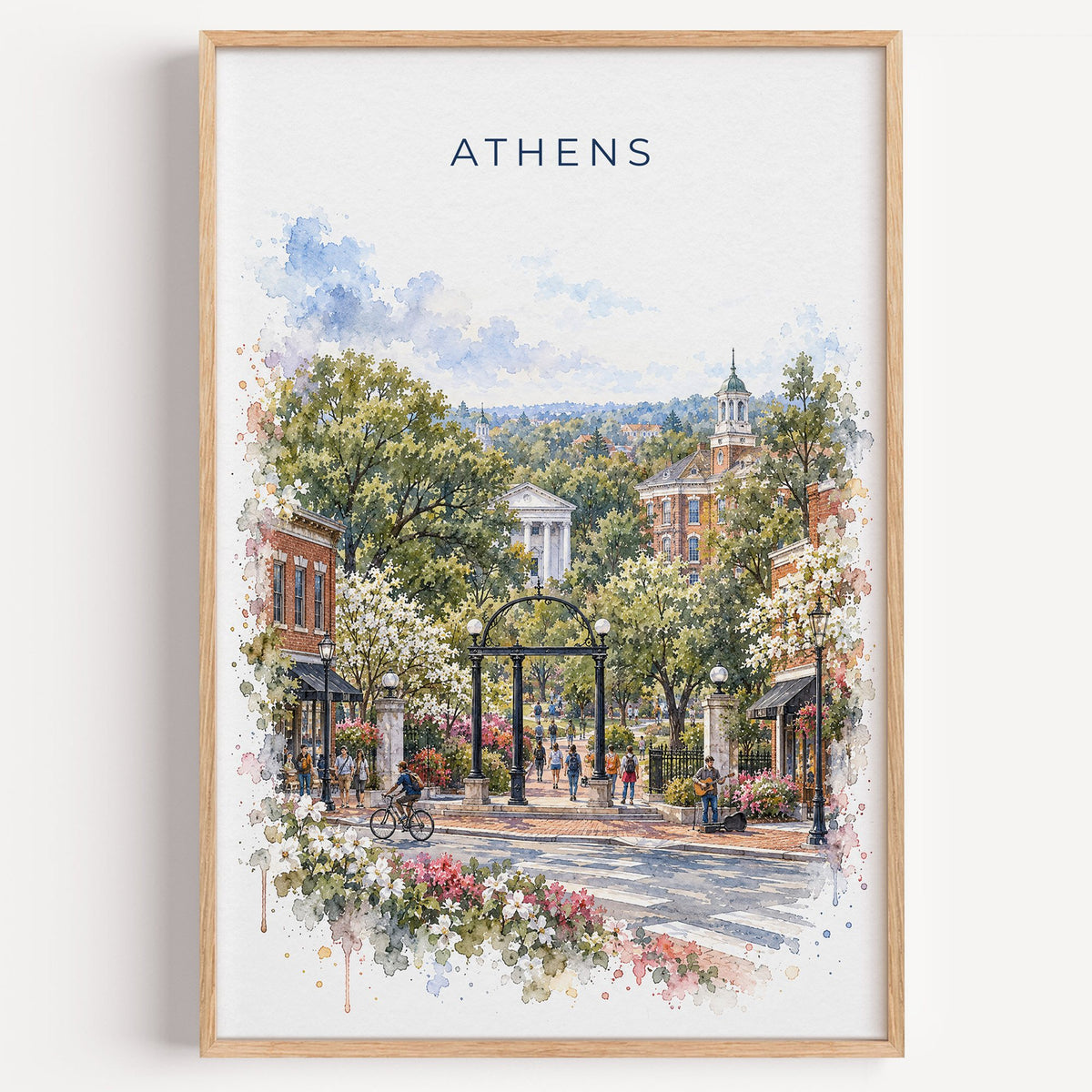 Athens, Georgia watercolor print in a light oak frame on a plain white wall