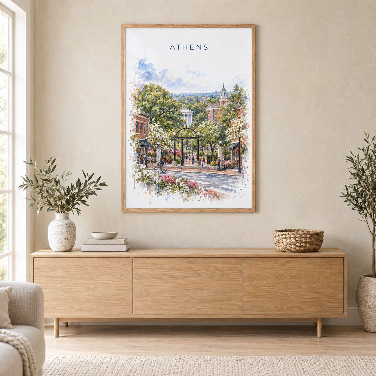 Athens, Georgia watercolor print in an oak frame above a light wood sideboard in a Scandinavian living room
