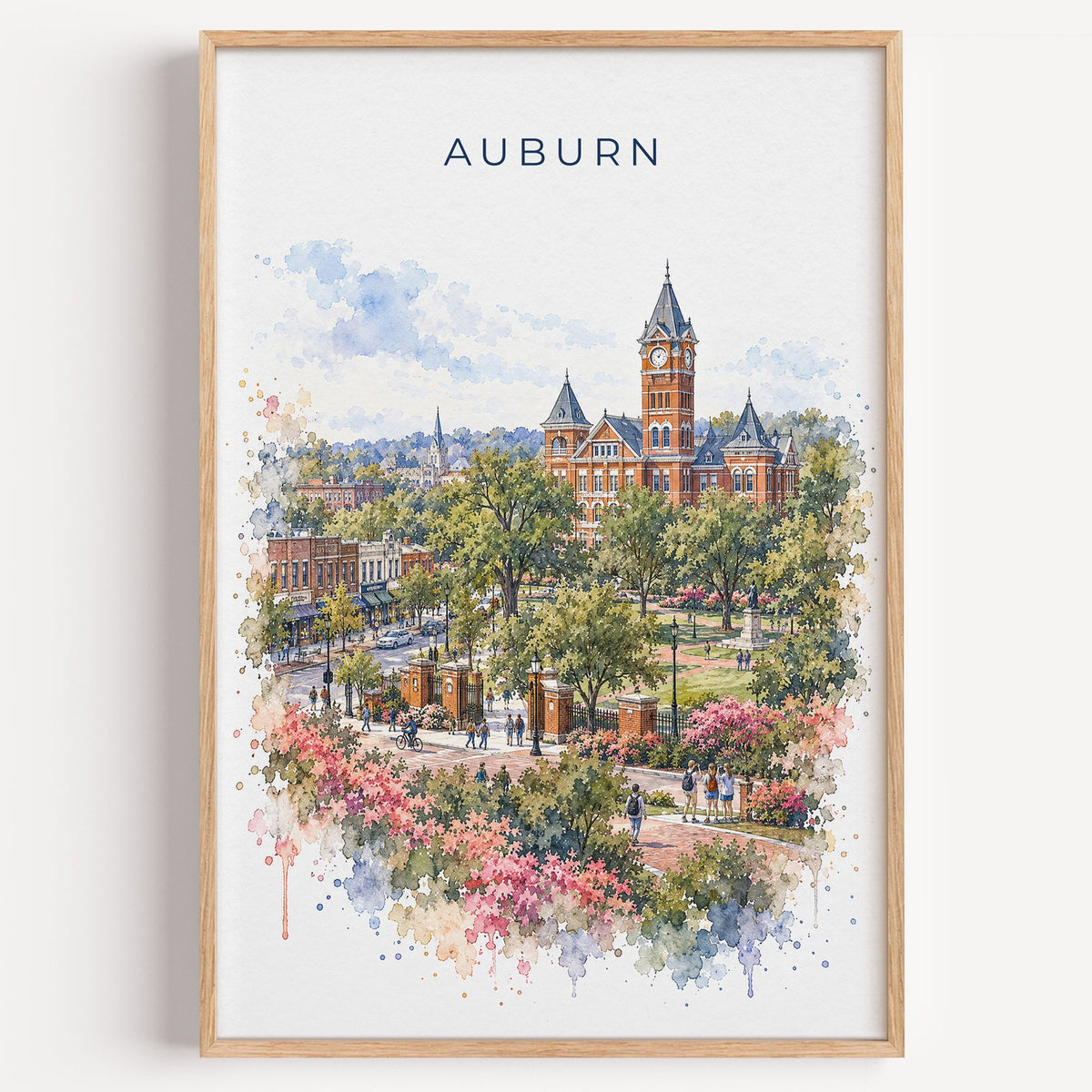 Auburn, Alabama watercolor print in a light oak frame on a plain white wall