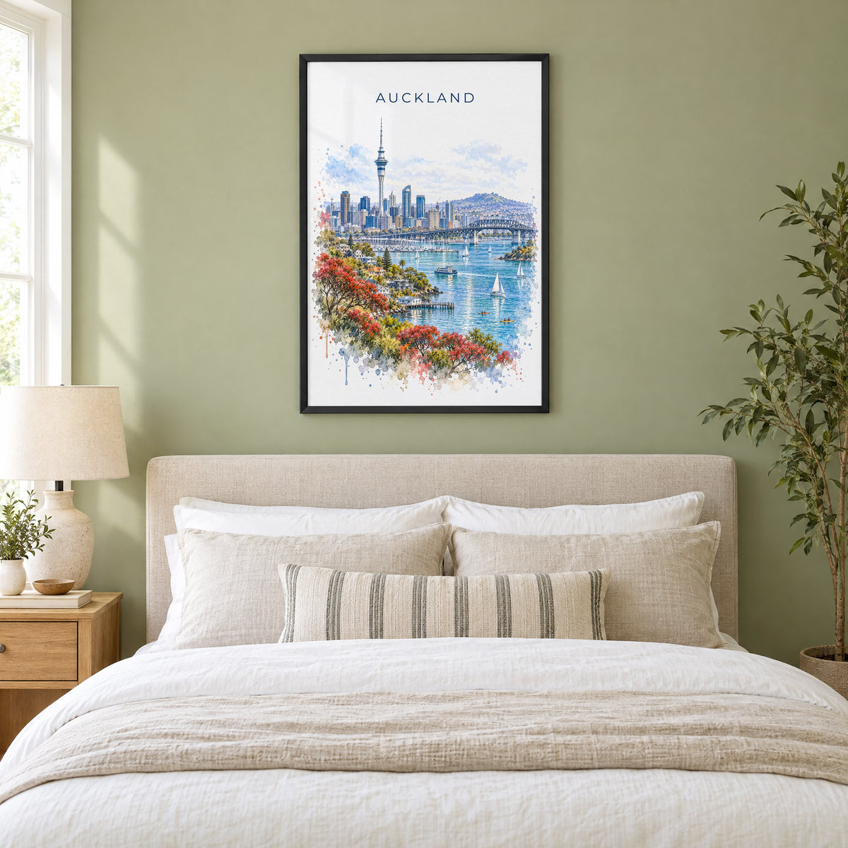 Auckland watercolor print in a black frame above an upholstered headboard in a sage green bedroom