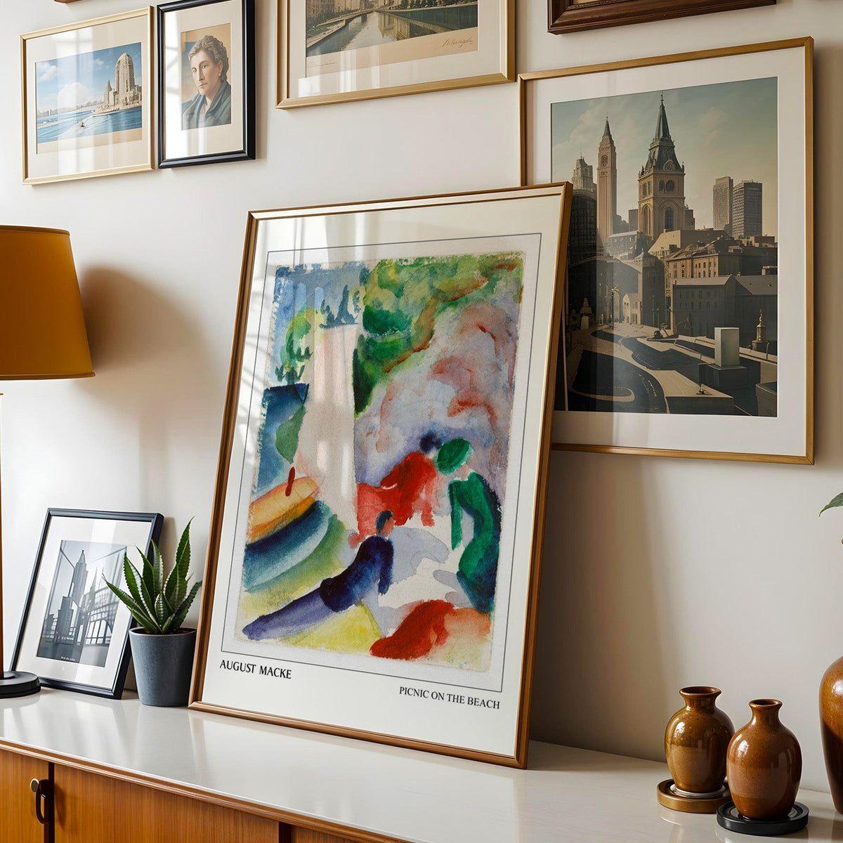 Macke print shown in a gold frame leaning on a sideboard in a gallery wall