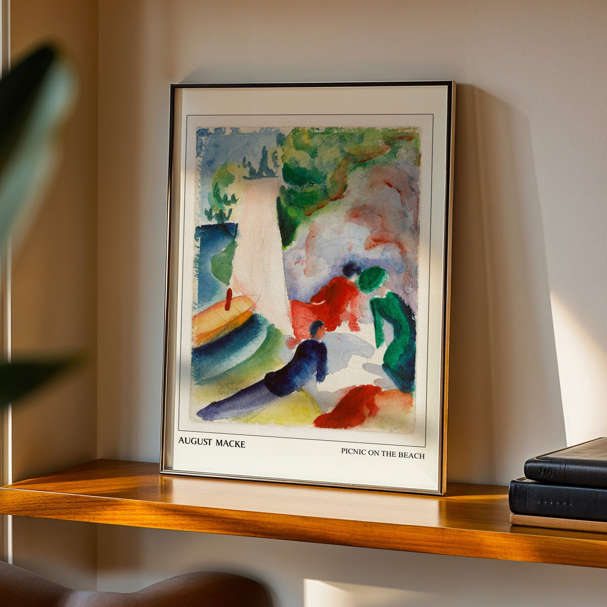 Picnic on the Beach print in a black frame on a walnut shelf in evening light
