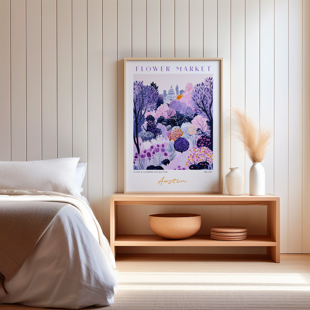 Austin flower market print in an oak frame on a wood bench against a white shiplap bedroom wall with pampas grass