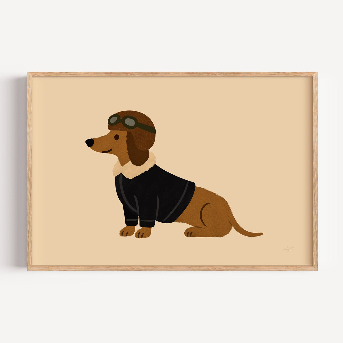 Dachshund in aviator cap nursery print in a light oak frame on a plain white wall