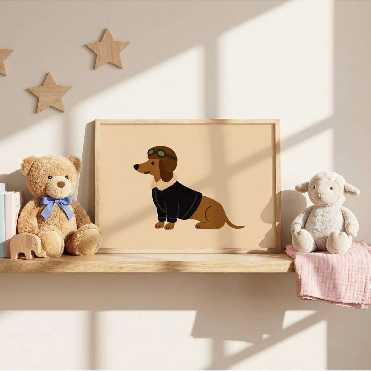 Dachshund in aviator cap nursery print in an oak frame on a wall shelf between a teddy bear and a toy lamb