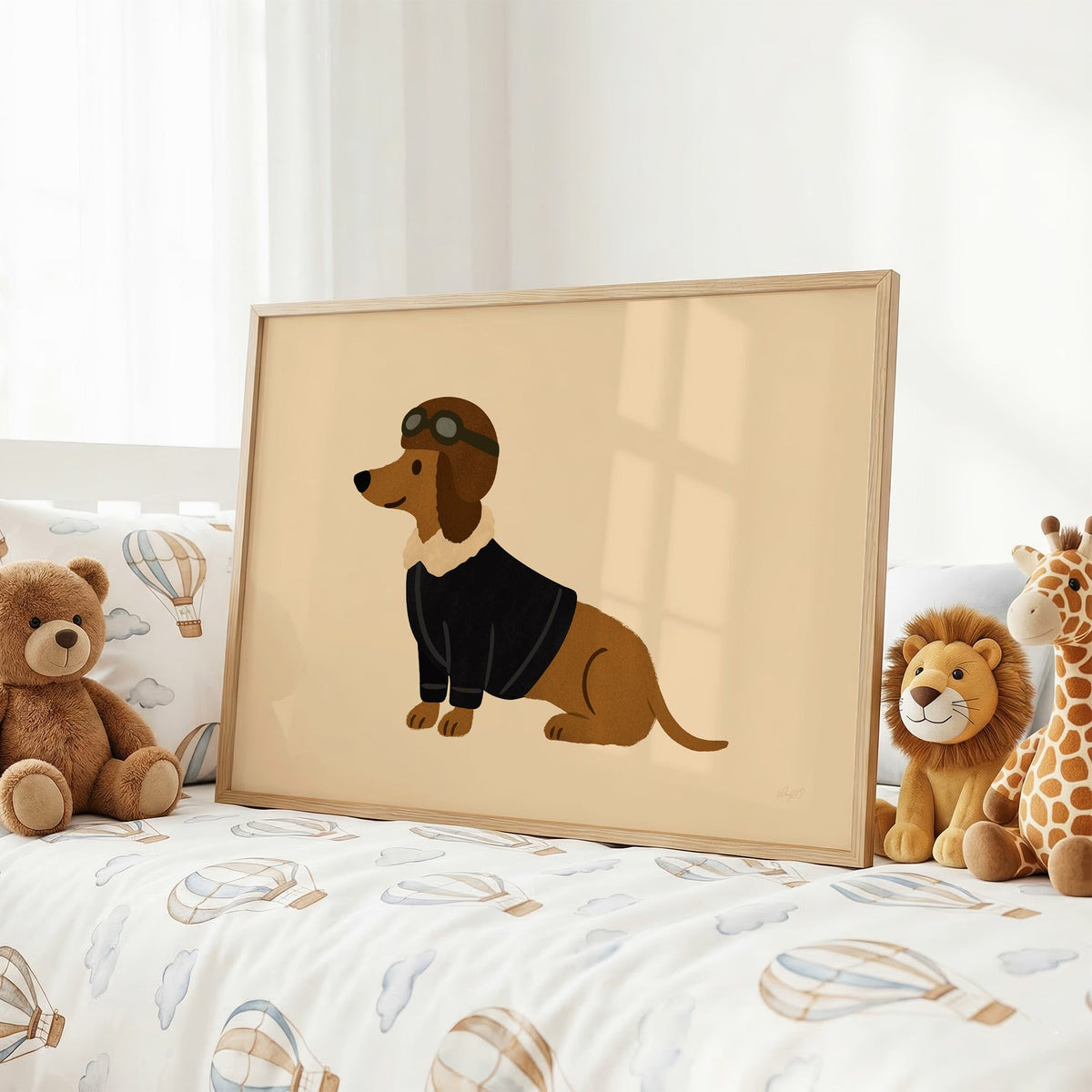 Dachshund in aviator cap nursery print in an oak frame on a kids bed with hot air balloon bedding
