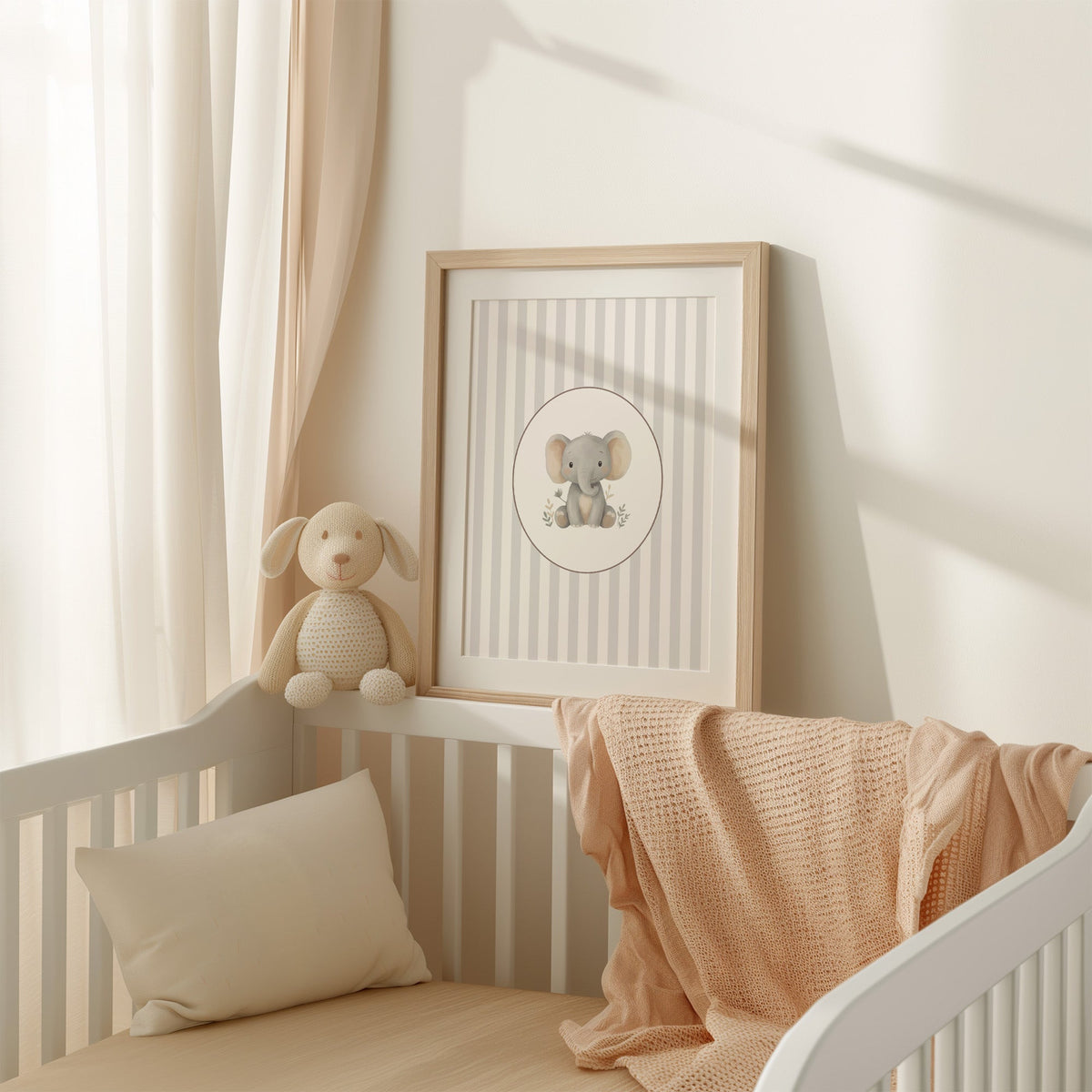 Baby elephant in a cream oval on grey stripes nursery print shown in an oak frame with a white mat on a crib rail