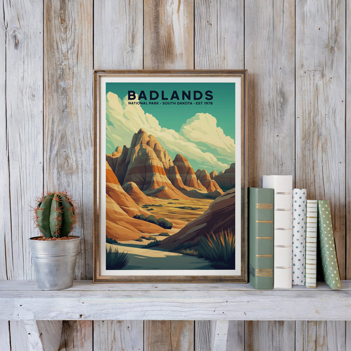 Badlands poster in an antique gold frame against whitewashed farmhouse planks beside books