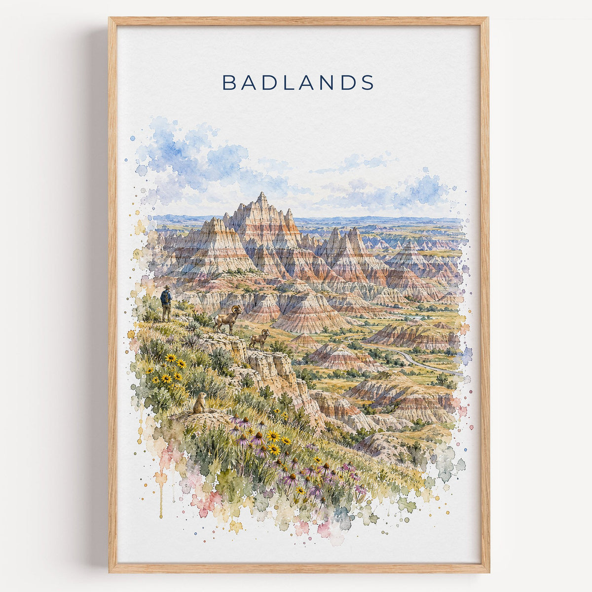 Badlands National Park watercolor print in a light oak frame on a plain white wall