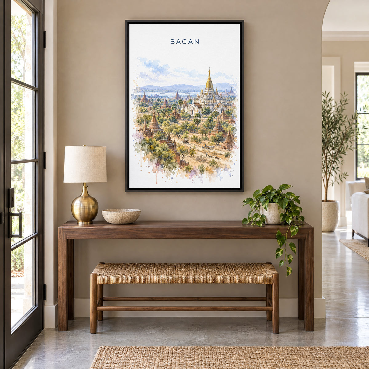Bagan watercolor print as a black floater canvas above a walnut console and woven bench in an entryway