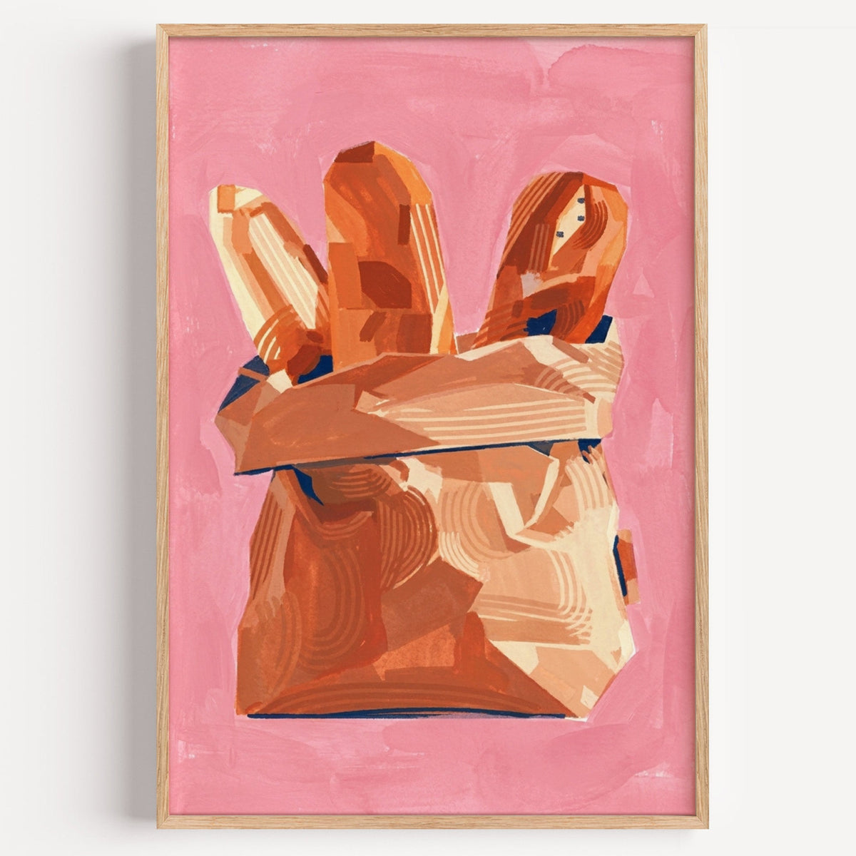 Baguettes in paper bag print in a light oak frame on a plain white wall