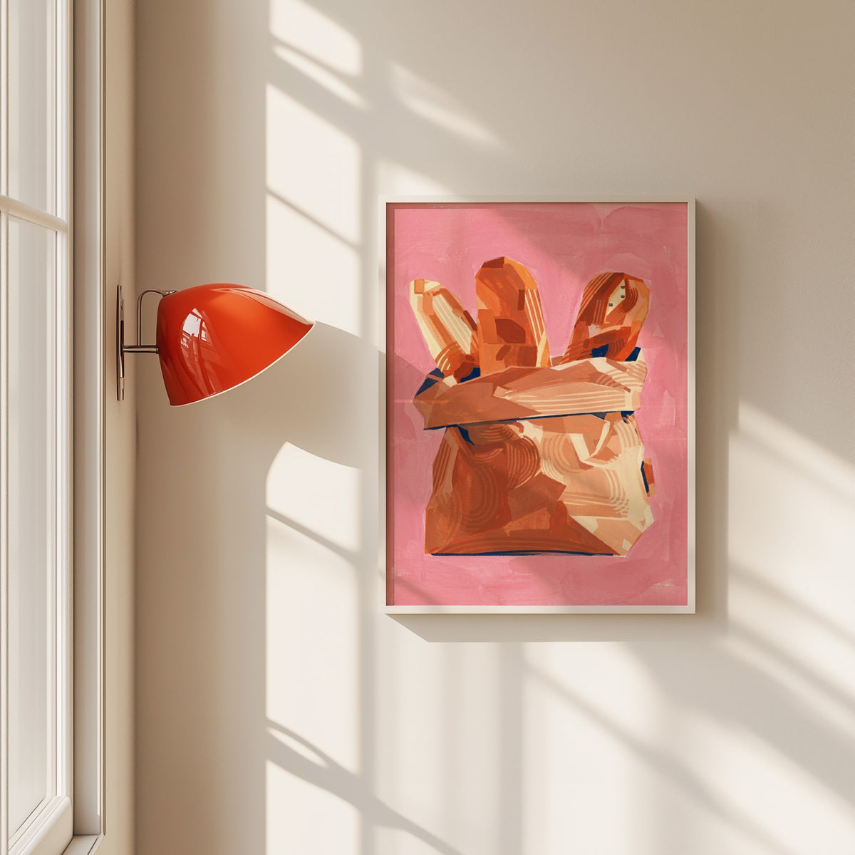 Baguettes in paper bag print in a white frame beside a red wall sconce