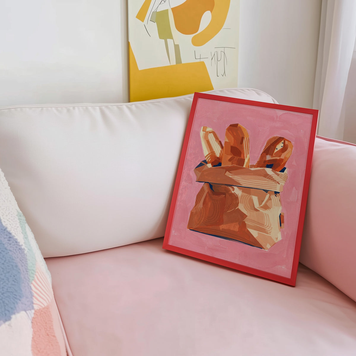 Baguette wall art print shown in a red frame leaning on a blush pink sofa