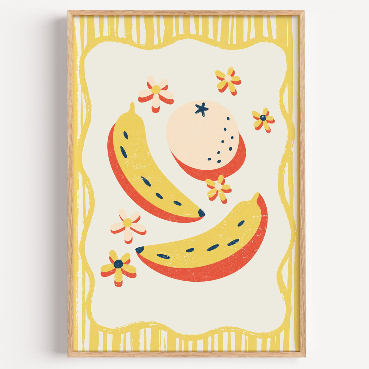 Banana and peach scatter print in a light oak frame on a plain white wall