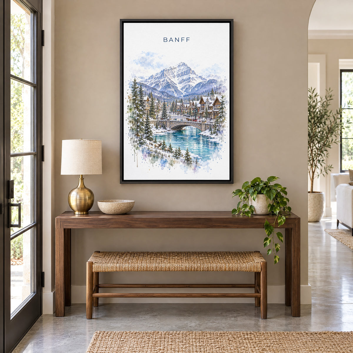 Banff watercolor print as a black floater canvas above a walnut console and woven bench in an entryway