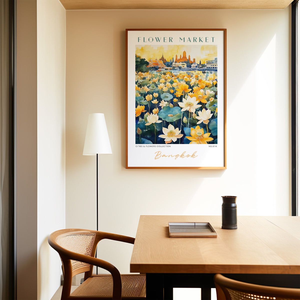 Bangkok flower market print in an oak frame above a dining table and cane chair