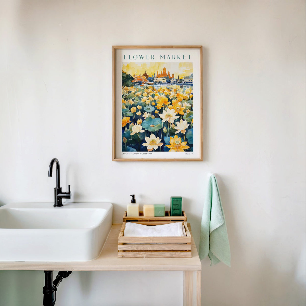 Bangkok flower market print in an oak frame above a white bathroom sink with folded towels