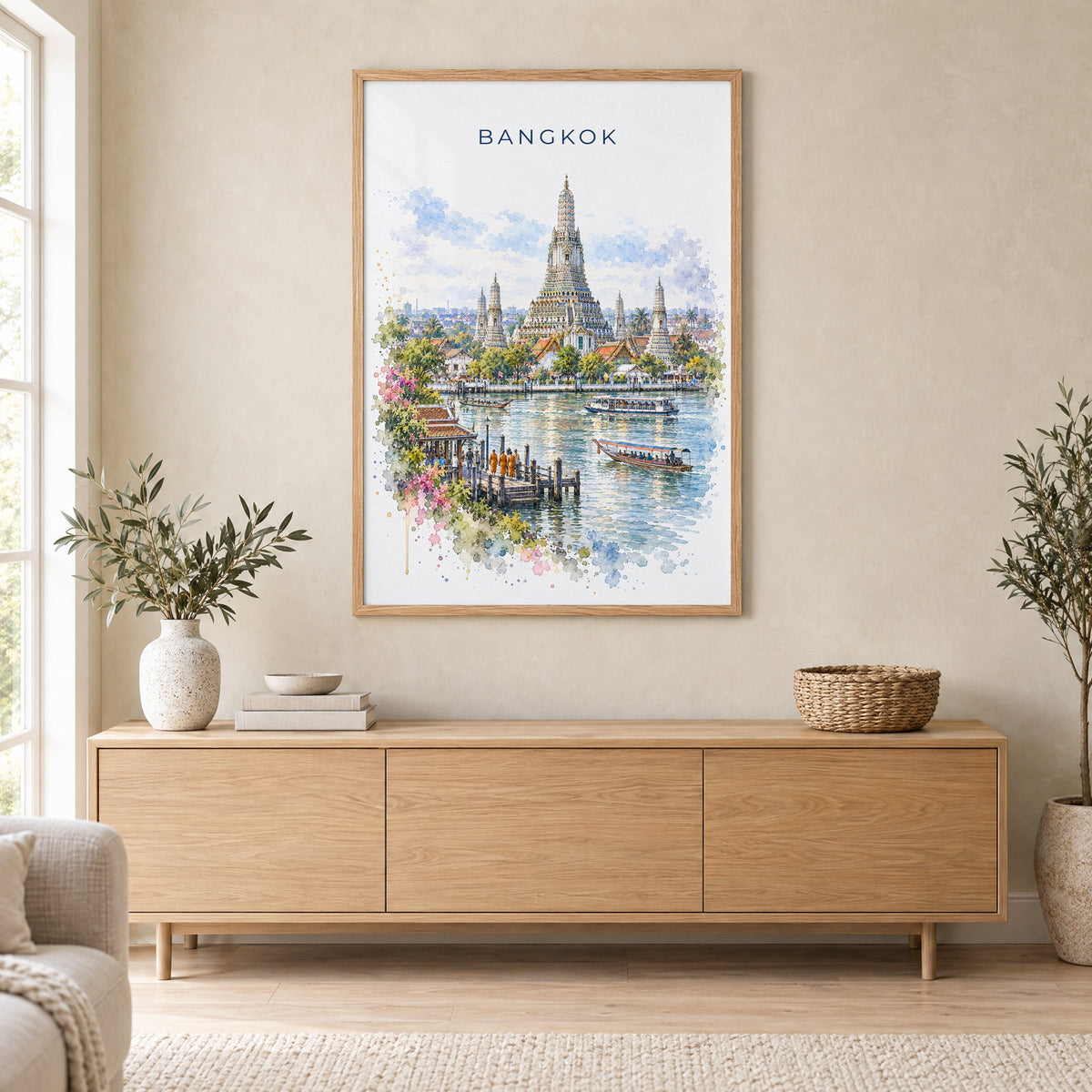 Bangkok watercolor print in an oak frame above a light wood sideboard in a Scandinavian living room