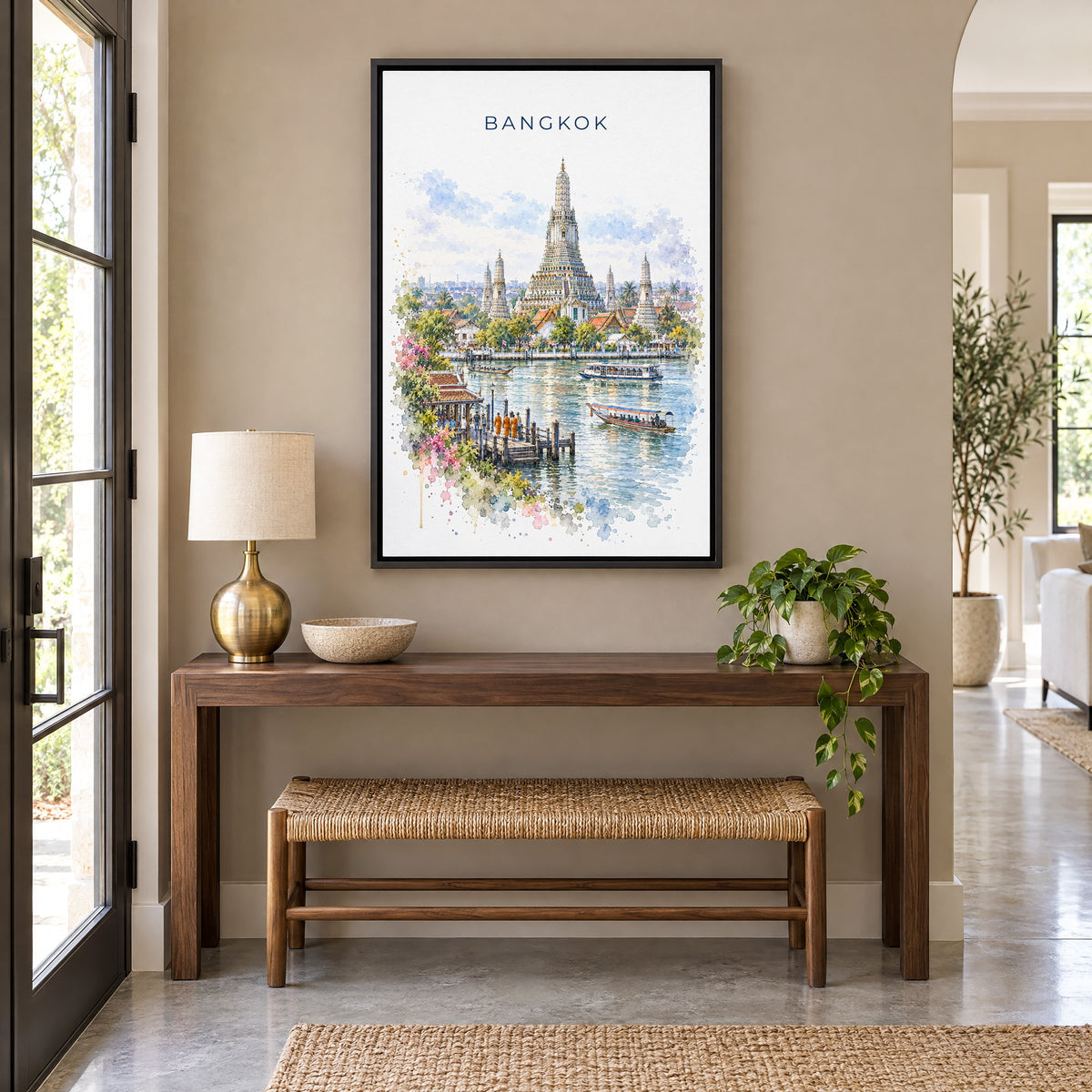 Bangkok watercolor print as a black floater canvas above a walnut console and woven bench in an entryway