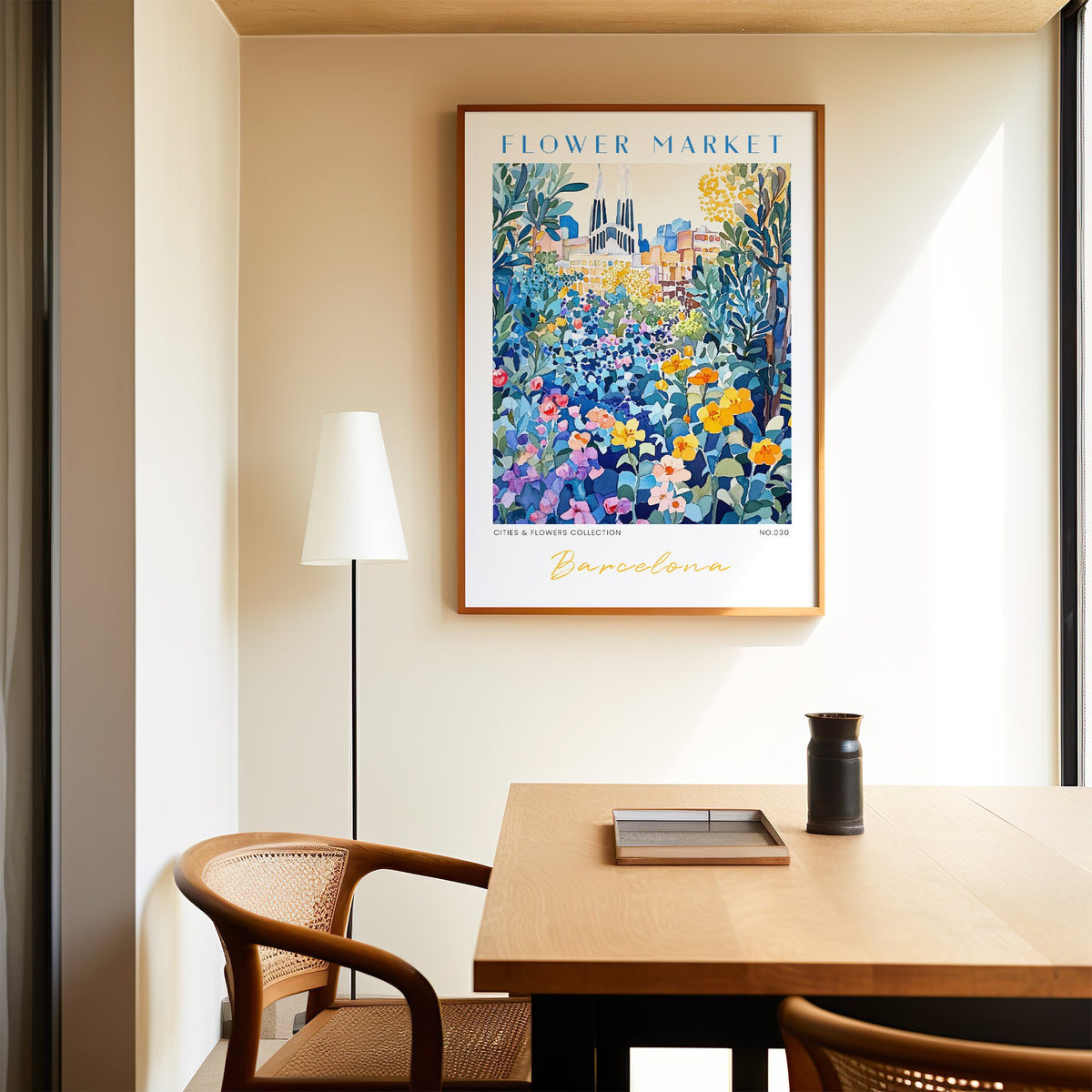 Barcelona flower market print in an oak frame above a dining table and cane chair