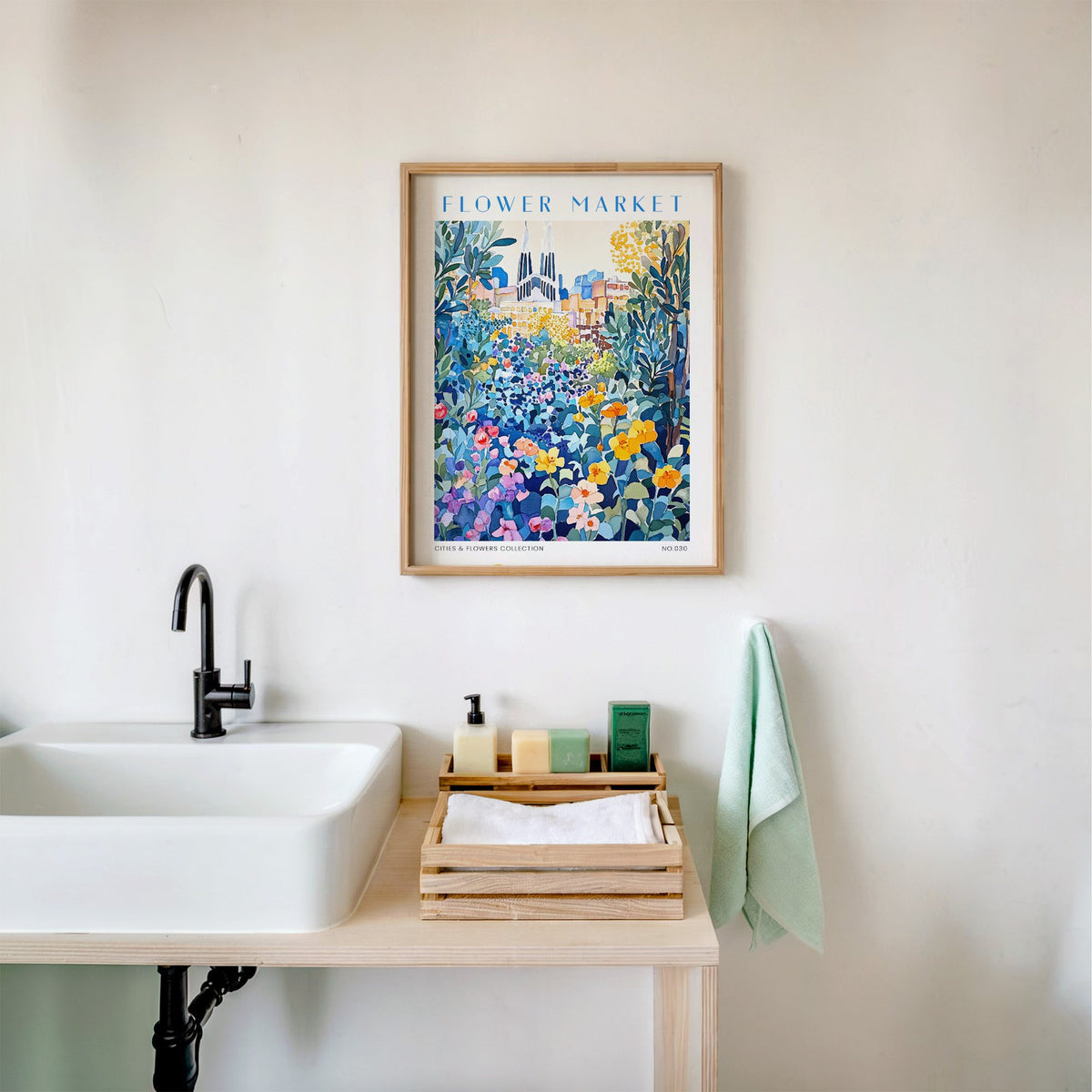 Barcelona flower market print in an oak frame above a white bathroom sink with folded towels