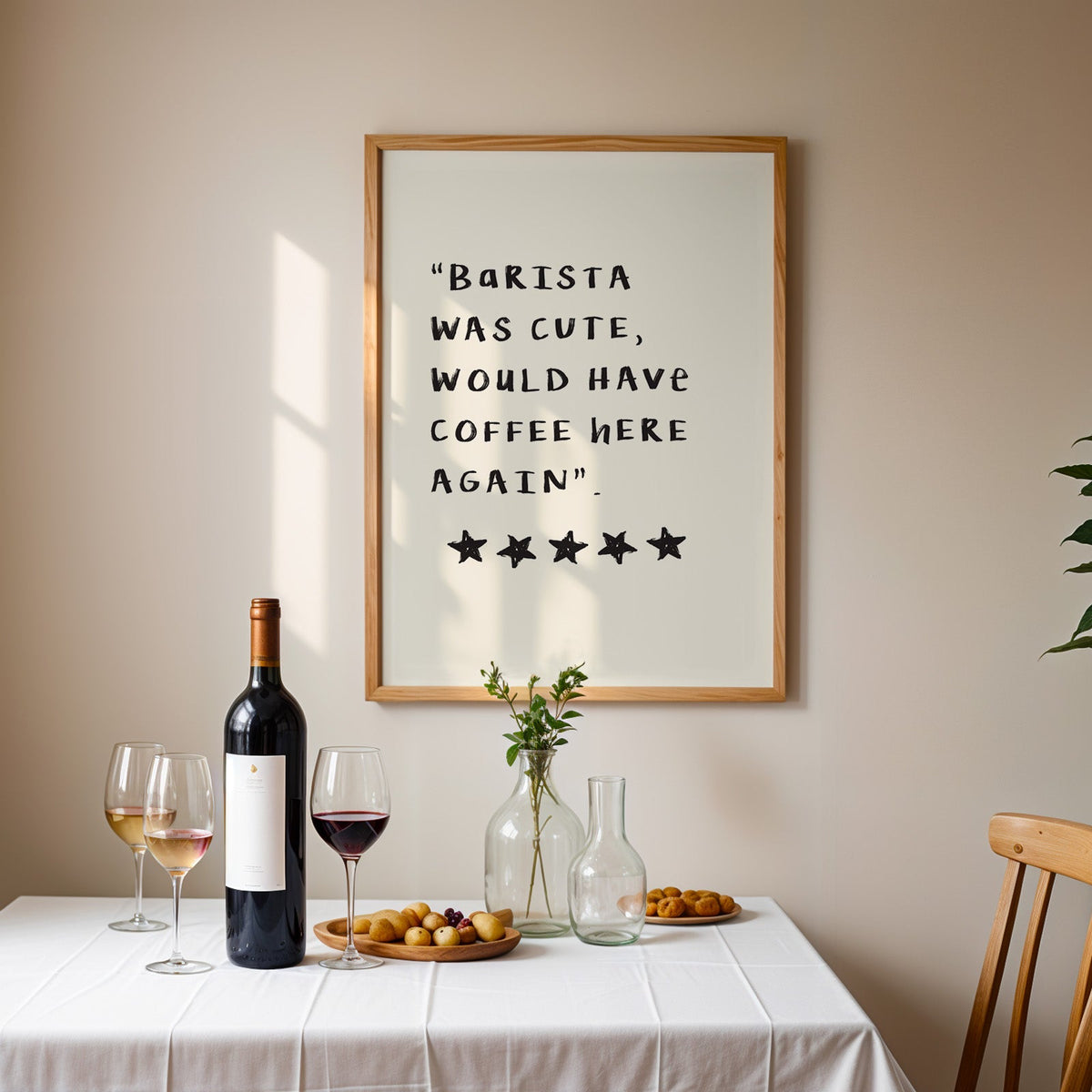 Barista was cute coffee print in an oak frame above a table laid with red wine and glasses