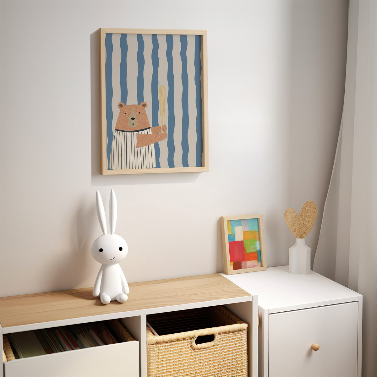 Baseball bear blue stripe nursery print in an oak frame above a kids cubby shelf with a woven basket and bunny lamp