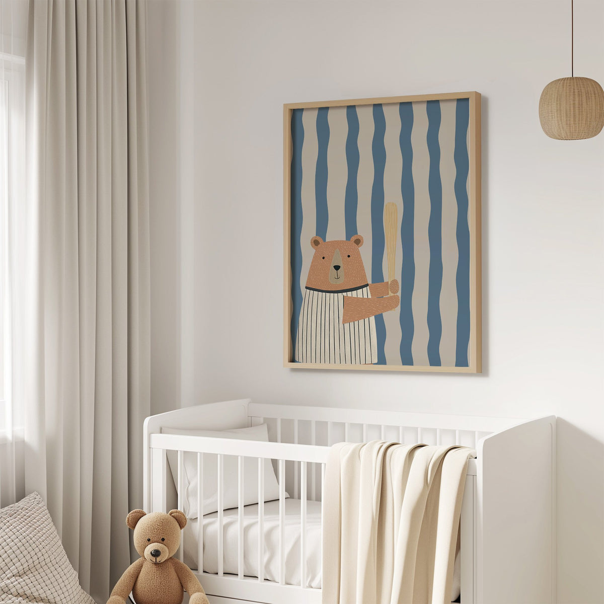 Baseball bear blue stripe nursery print in an oak frame above a white crib with a teddy bear