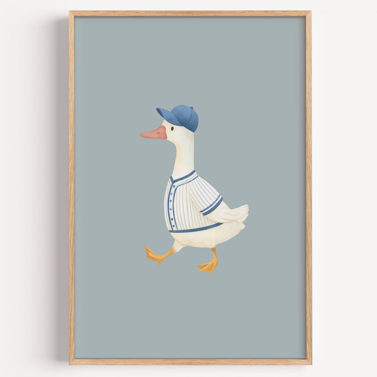 Baseball bird blue cap nursery print in a light oak frame on a plain white wall