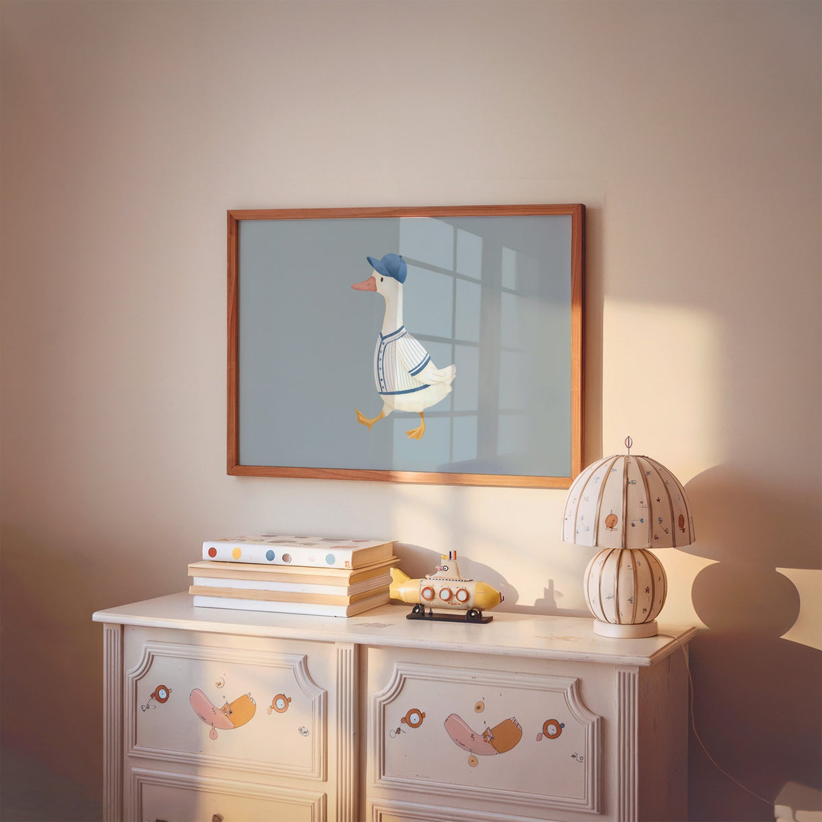 Landscape baseball bird blue cap nursery print in a cherry wood frame above a painted dresser and lamp