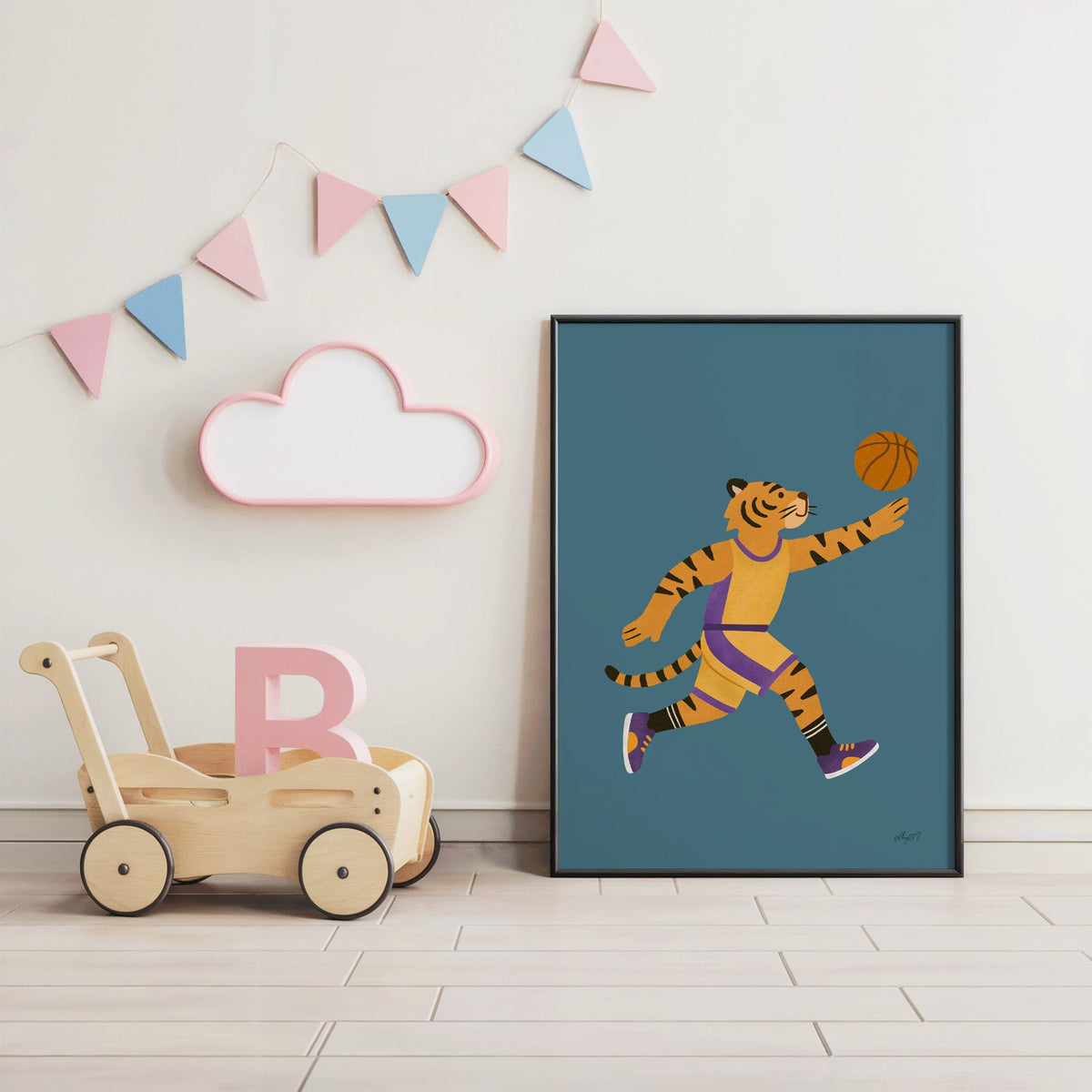Tiger playing basketball nursery print in a black frame under pastel bunting by a wooden baby walker
