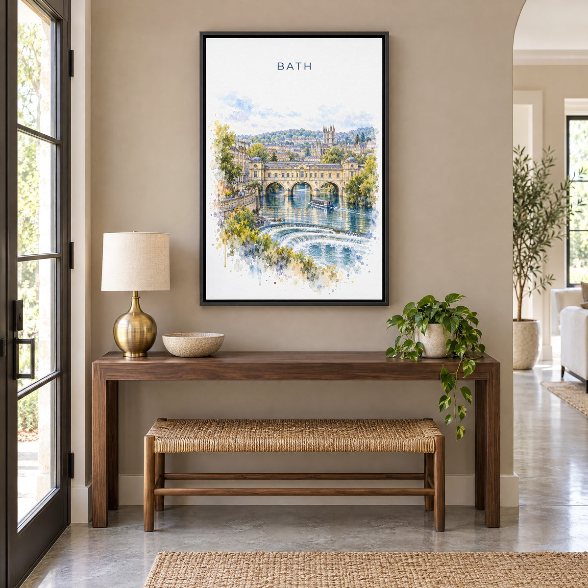 Bath, England watercolor print as a black floater canvas above a walnut console and woven bench in an entryway
