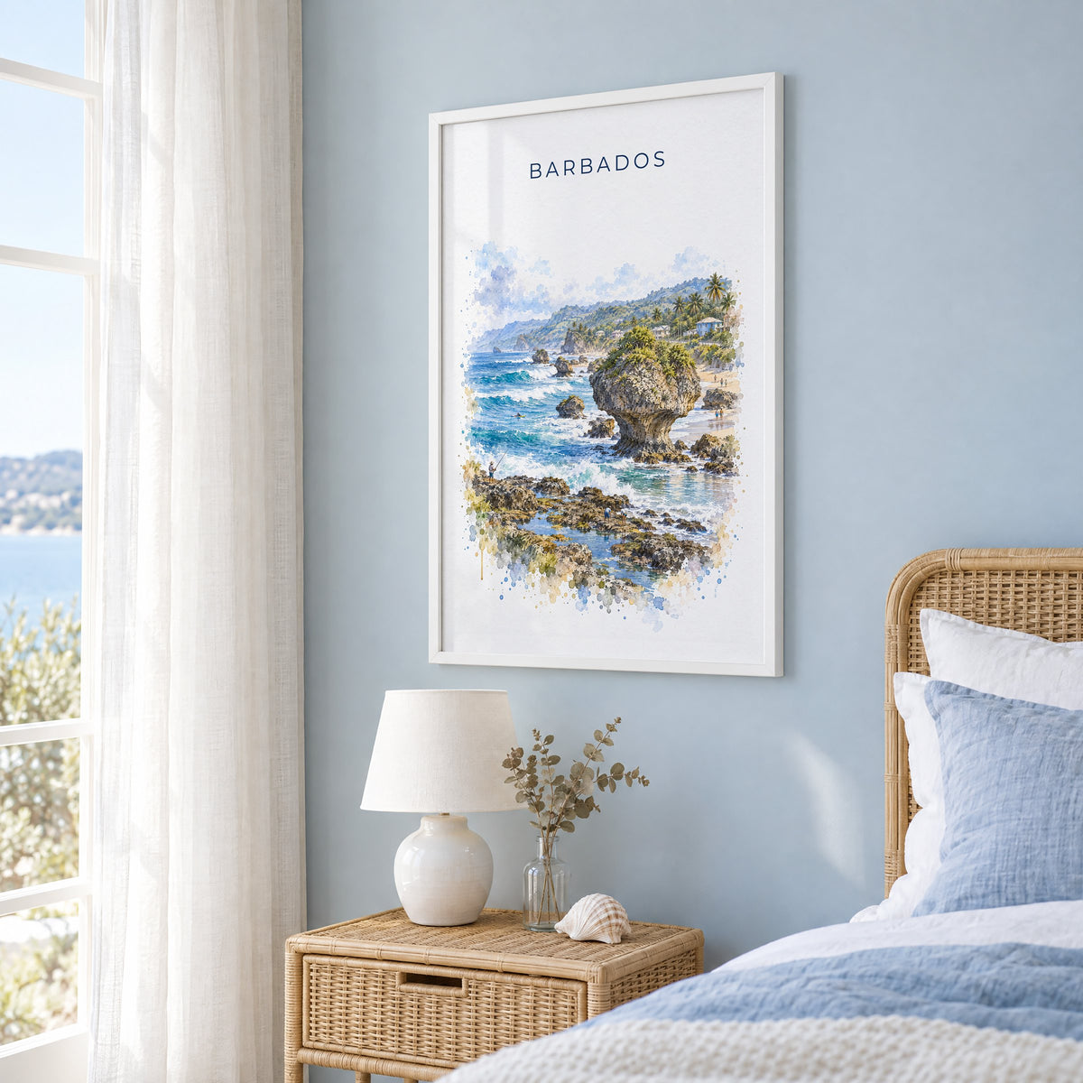 Barbados watercolor print in a white frame on a pale blue wall beside a rattan bed in a coastal bedroom
