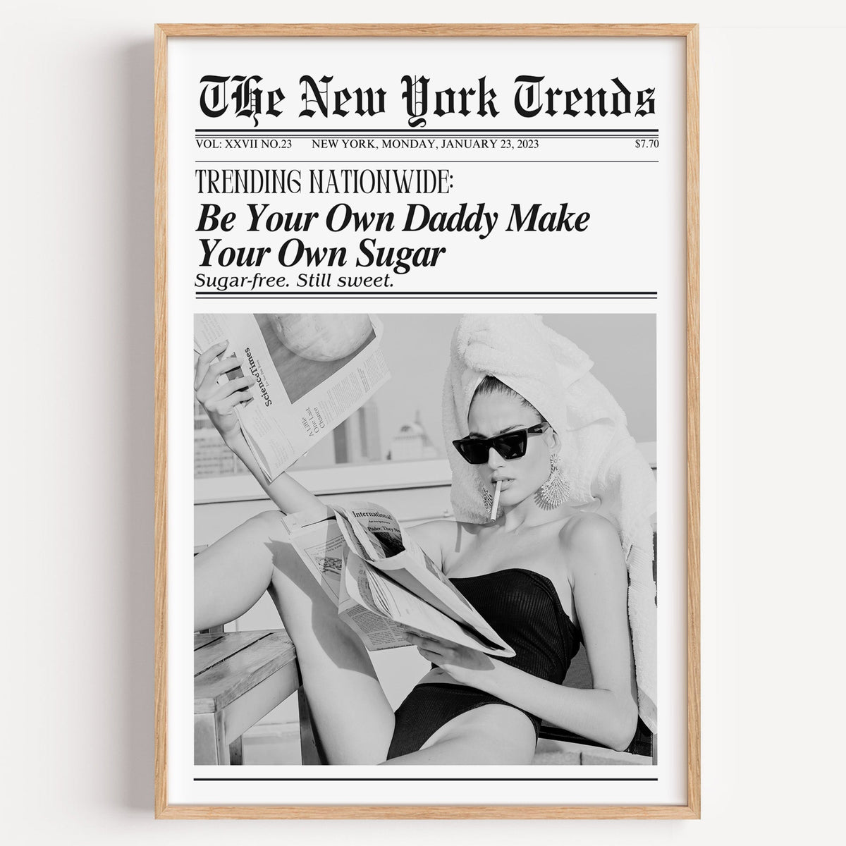 Woman reading newspapers on rooftop mock front page print in a light oak frame on a plain white wall